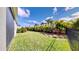 Lush backyard featuring well-maintained lawn, tropical plants, and a black fence at 5645 Del Coronado Dr, Apollo Beach, FL 33572