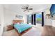Primary bedroom with a wood frame bed, ensuite bathroom, and windows overlooking a manicured yard at 5645 Del Coronado Dr, Apollo Beach, FL 33572