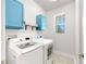 Bright laundry room featuring modern washer and dryer, complemented by blue cabinets at 5645 Del Coronado Dr, Apollo Beach, FL 33572