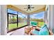 Screened patio with fan, outdoor seating, and view of well-maintained backyard at 5645 Del Coronado Dr, Apollo Beach, FL 33572
