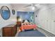 Comfortable bedroom with a wood-look floor features ample closet space and a blue accent wall at 5728 14Th N Ave # 101B, St Petersburg, FL 33710
