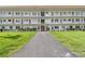 Condo building with a gray entryway path, white facade, red accents, and landscaped green lawn at 5728 14Th N Ave # 101B, St Petersburg, FL 33710