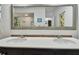 Bright bathroom boasts a double sink vanity with a large framed mirror and neutral decor at 5961 36Th Ave N, St Petersburg, FL 33710