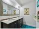 Bright bathroom boasts a double sink vanity with a large framed mirror and blue tiled floors at 5961 36Th Ave N, St Petersburg, FL 33710