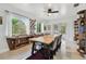 Dining room with a long wooden table, chairs, bookshelves, and natural light from windows at 5961 36Th Ave N, St Petersburg, FL 33710