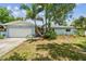 Charming single-story home featuring a lush landscaped front yard with mature palm trees and an attached garage at 5961 36Th Ave N, St Petersburg, FL 33710