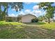 Expansive backyard area, partially shaded by mature trees, offering space and privacy at 6121 Piedmont Dr, Spring Hill, FL 34606