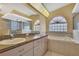 Well-lit bathroom featuring a double sink vanity, garden tub, and walk-in shower at 6121 Piedmont Dr, Spring Hill, FL 34606
