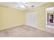 Carpeted bedroom with double door closet, light walls, ceiling fan, and hallway access at 6121 Piedmont Dr, Spring Hill, FL 34606