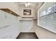 Walk-in closet with shelving, carpeted floor, a window, and overhead lighting at 6121 Piedmont Dr, Spring Hill, FL 34606