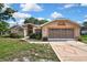 Charming single-story home with a large garage and well-maintained front yard at 6121 Piedmont Dr, Spring Hill, FL 34606