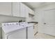 Bright laundry room with tile floors, washer, dryer, cabinets and utility sink at 6121 Piedmont Dr, Spring Hill, FL 34606