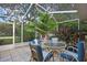 Screened in patio with tile floor, outdoor furniture and view of backyard and trees at 6121 Piedmont Dr, Spring Hill, FL 34606