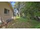 Lush side yard of the home, featuring mature trees for added privacy and shade at 6121 Piedmont Dr, Spring Hill, FL 34606