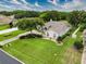 Expansive home featuring manicured lawns, mature trees, and a long driveway, nestled in a lush green neighborhood under a bright sky at 6204 Rockross Ave, New Port Richey, FL 34655