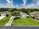 Expansive home featuring manicured lawns, mature trees, and a long driveway, nestled in a lush green neighborhood under a bright sky at 6204 Rockross Ave, New Port Richey, FL 34655