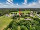 Wide aerial view of home surrounded by trees, a pond and green expanses at 6204 Rockross Ave, New Port Richey, FL 34655