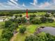 Aerial view of a home with a screened-in pool, surrounded by a fenced yard, mature trees, and a pond at 6204 Rockross Ave, New Port Richey, FL 34655
