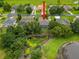 Aerial view of a home with a screen enclosed pool and lush trees and landscape at 6204 Rockross Ave, New Port Richey, FL 34655