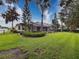 This backyard features a large screened-in pool, a well-kept lawn, and mature landscaping at 6204 Rockross Ave, New Port Richey, FL 34655