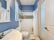 This bathroom features blue walls, mosaic shower tiles, a door, and a vintage-style sink and toilet at 6204 Rockross Ave, New Port Richey, FL 34655