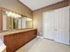 Spacious bathroom featuring a granite countertop, tiled flooring, and double-door closet at 6204 Rockross Ave, New Port Richey, FL 34655