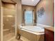 Elegant bathroom showcasing a luxurious soaking tub and glass enclosed shower at 6204 Rockross Ave, New Port Richey, FL 34655