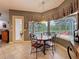 Bright breakfast nook features tile floors, stylish table, and view of the screened-in lanai and pool at 6204 Rockross Ave, New Port Richey, FL 34655
