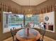 Bright dining area offers views of the pool, outdoor kitchen, and screened-in patio through a bay window at 6204 Rockross Ave, New Port Richey, FL 34655