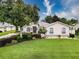 Charming single-story home featuring a lush landscaped yard, mature trees, and a well-maintained lawn on a sunny day at 6204 Rockross Ave, New Port Richey, FL 34655