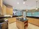 Open kitchen featuring custom cabinets, granite countertops, an island, and a view into the lanai at 6204 Rockross Ave, New Port Richey, FL 34655