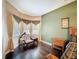 Comfortable primary bedroom details include an elegant chaise, and hardwood flooring at 6204 Rockross Ave, New Port Richey, FL 34655