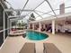 Spacious screened-in pool area featuring a spa, ample seating, and an outdoor kitchen at 6204 Rockross Ave, New Port Richey, FL 34655