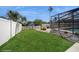 Well-maintained backyard with grassy area, pool with enclosure and white fence at 6503 Santiago Ct, Apollo Beach, FL 33572