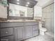 Bathroom featuring a double vanity with a granite countertop and tiled shower with glass door at 6503 Santiago Ct, Apollo Beach, FL 33572