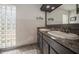Bathroom with double sinks, a glass block window, and neutral finishes at 6503 Santiago Ct, Apollo Beach, FL 33572