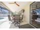 Relaxing covered patio with tiled flooring, ceiling fan, and comfortable seating area next to pool at 6503 Santiago Ct, Apollo Beach, FL 33572