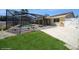 Backyard pool features a screened enclosure, a grassy area, and concrete paving at 6503 Santiago Ct, Apollo Beach, FL 33572