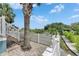 Charming backyard features a paved patio area with white picket fence overlooking waterfront at 6512 Simone Shores Cir, Apollo Beach, FL 33572
