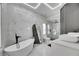 Modern bathroom with marble walls, a soaking tub, an enclosed shower, and dual vessel sinks at 6512 Simone Shores Cir, Apollo Beach, FL 33572
