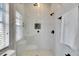 Bathroom featuring a luxurious glass shower with black fixtures, marble-look tile, and a window for natural light at 6512 Simone Shores Cir, Apollo Beach, FL 33572