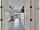 View into a bedroom with wood floors, ceiling fan, flat screen TV, and sliding door to balcony at 6512 Simone Shores Cir, Apollo Beach, FL 33572