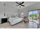 Bedroom with light wood floors, a ceiling fan, a bed, and a chair with an ottoman at 6512 Simone Shores Cir, Apollo Beach, FL 33572