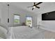 Bedroom with hardwood floors, a ceiling fan, chair with ottoman, and sliding door to balcony at 6512 Simone Shores Cir, Apollo Beach, FL 33572