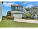 A coastal home with blue siding, a two-car garage, and a well-maintained lawn at 6512 Simone Shores Cir, Apollo Beach, FL 33572