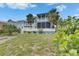 Beautiful two-story home showcases a backyard with lawn, palm trees, and white picket fence at 6512 Simone Shores Cir, Apollo Beach, FL 33572