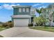 Two-story home featuring a white garage door, second story balcony, and landscaping at 6512 Simone Shores Cir, Apollo Beach, FL 33572