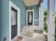 Charming front porch with teal wall features a black front door at 6512 Simone Shores Cir, Apollo Beach, FL 33572