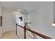 Upstairs hallway with hardwood floors, white walls, wood railing, and an open view to the living room at 6512 Simone Shores Cir, Apollo Beach, FL 33572