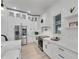 Modern white kitchen featuring stainless steel appliances, a cozy window nook, and an island with barstool seating at 6512 Simone Shores Cir, Apollo Beach, FL 33572